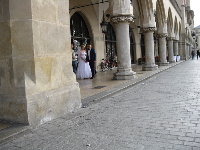 A couple poses in market square for their wedding photographer.