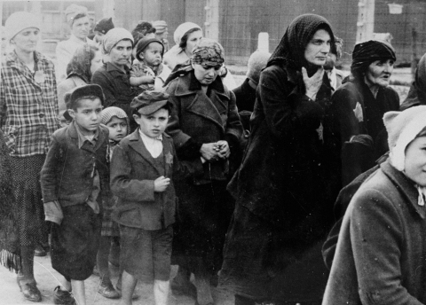 Women and children selected for death, walking unknowingly toward gas chambers, upon arriving at Birkenau.